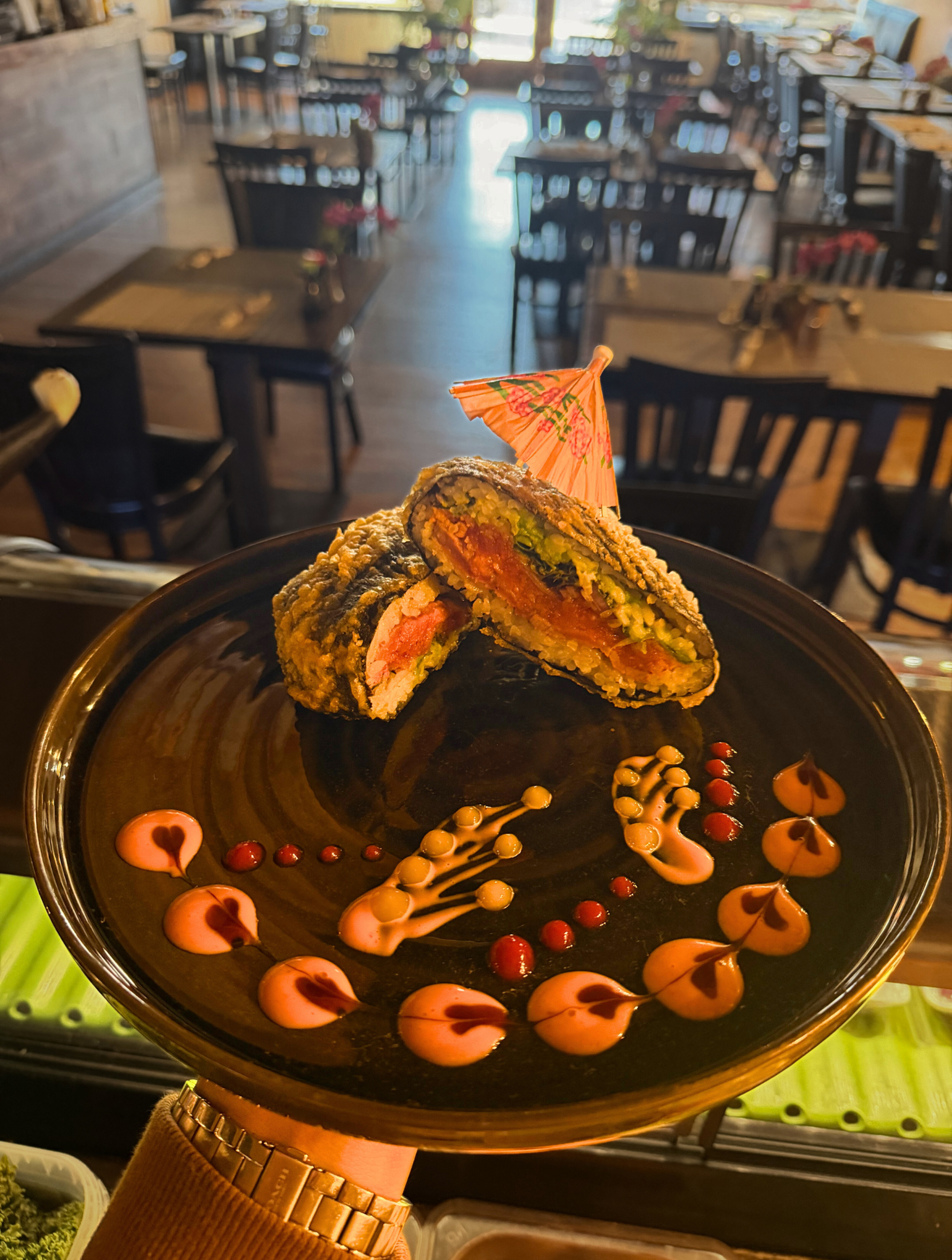 Suwana Asian Cuisine's Country Sushi Burger on a plate, framed by decorative swirls of sauce.